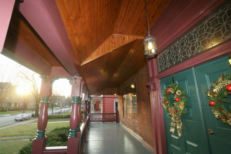 The wraparound porch with green doors and wreaths