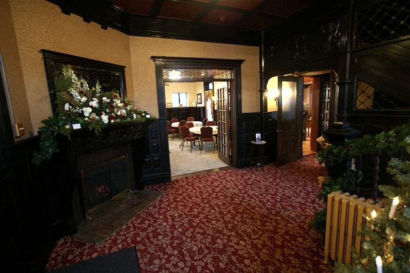 The foyer of 870 West Fourth Street, dark wood and patterned carpet